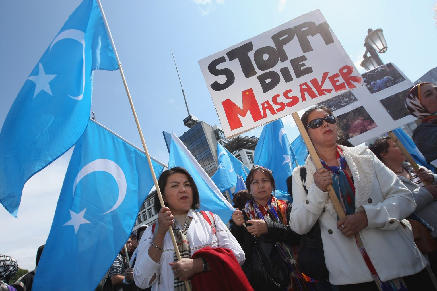 Uighurs hold East Turkistan flags and a sign that reads "Stop The Massacres" near the Chinese embassy in Berlin. Sean Gallup/Getty Images