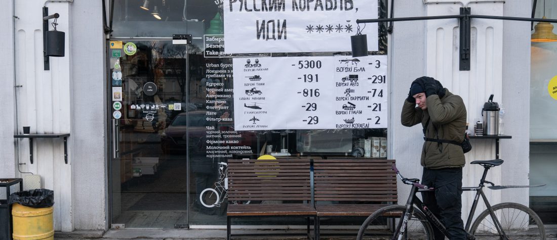 IVANO-FRANKIVSK, UKRAINE - FEBRUARY 28: A man with a bicycle is seen next to a cafe that has a sign "Russian Warship, go **** yourself", and another sign with the numbers of people and vehicles Russia lost in the recent war with Ukraine, on February 28, 2022 in Ivano-Frankivsk, Ukraine. Ukrainians from the eastern and central parts of the country have increasingly fled to western cities as Russian forces advance toward Kyiv from three sides. Russia launched a large-scale invasion of Ukraine last week, prompting widespread condemnation from European countries, coupled with sanctions on Russia and promises of military support for Ukraine. (Photo by Alexey Furman/Getty Images)