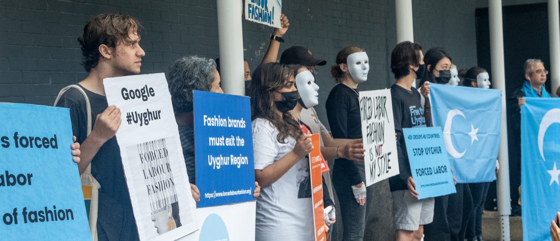 A protest against Uyghur forced labor by major fashion brands Nike, Uniqlo, Zara and Fila. 
In this image a group of “human mannequin” characters are posing at the entrance of New York Fashion Week event stating the abuse of these major clothing and fashion brands.